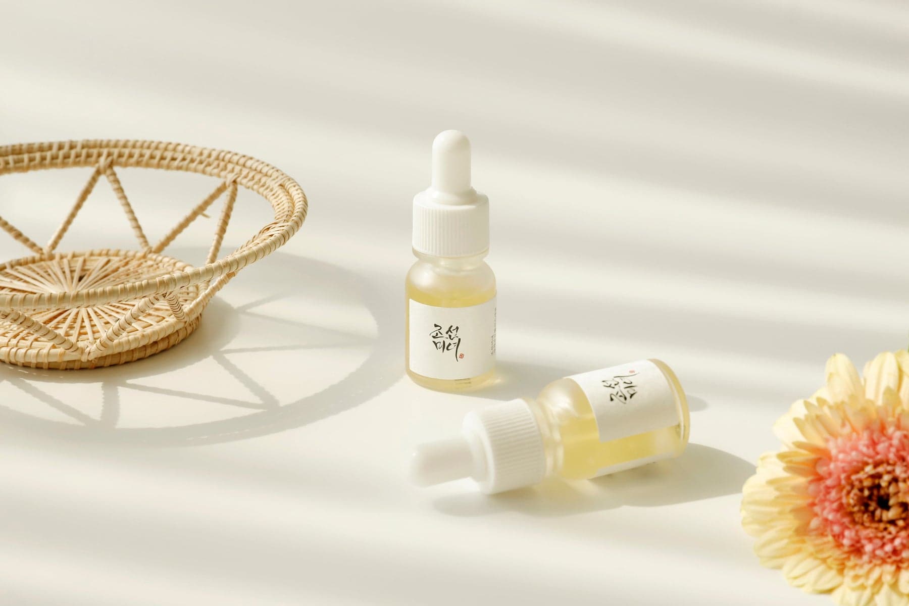 Fotografia oficial Beauty of Joseon: Glow Serum com flores e uma bandeja de fibras naturais